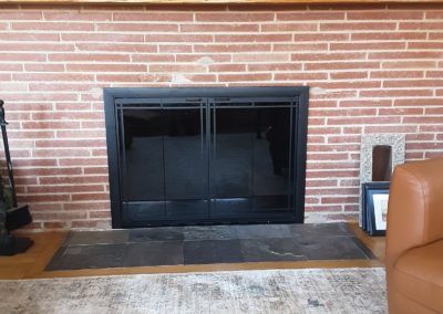 fireplace doors with brick surround after